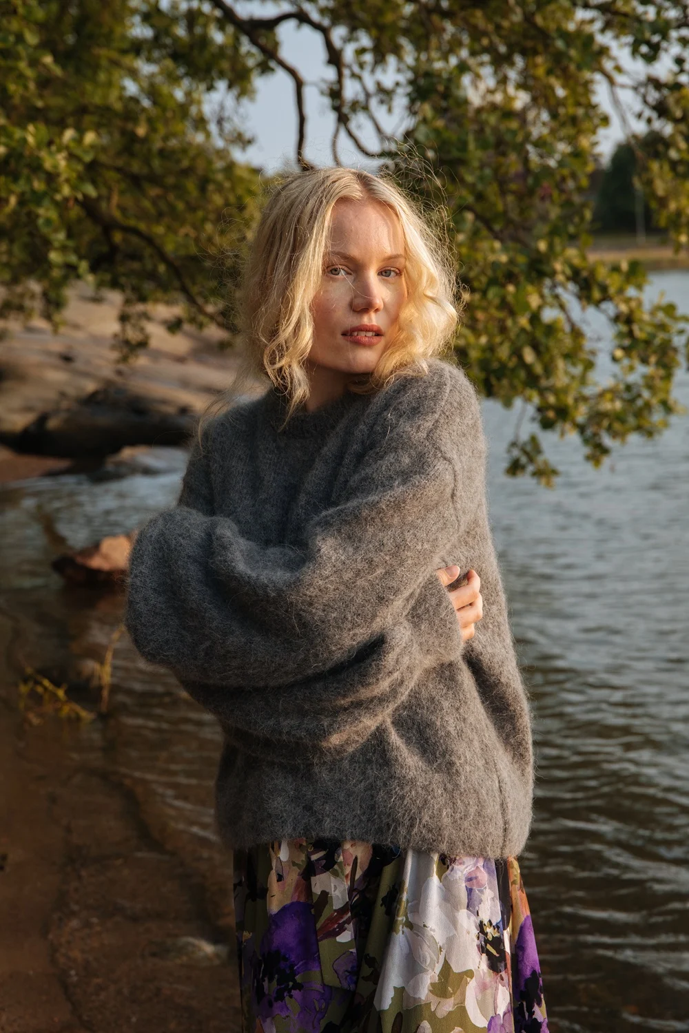 Charlotta veden äärellä harmaassa neuleessa ja Kaikon Olive Anemone -kuosisessa Wrap Midi Dress -mekossa